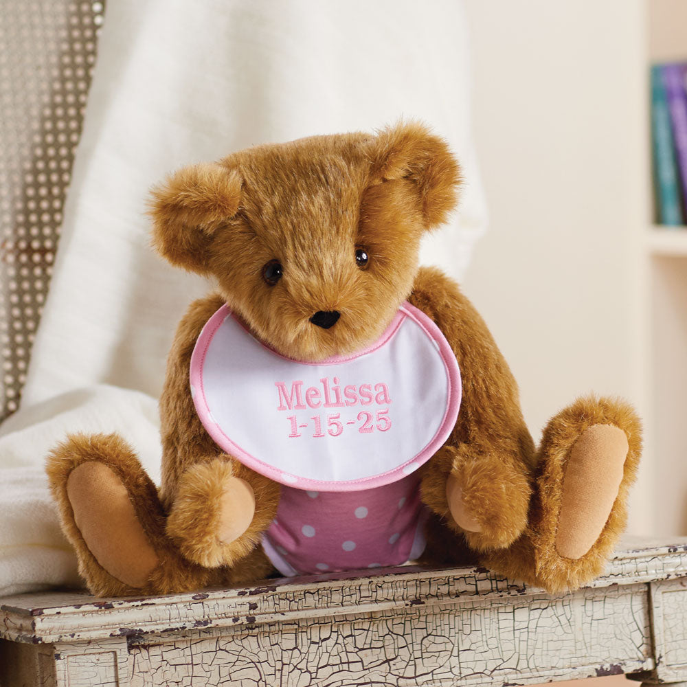 Honey-colored plush teddy bear wearing a pink bib embroidered with "Melissa 1-15-25" and pink polka dot diaper.