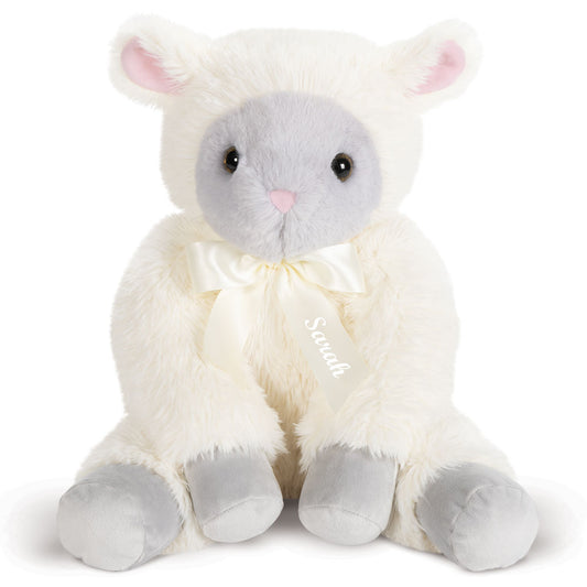 Plush lamb toy with fluffy white fur, gray face and feet, pink ears, and a cream ribbon bow around its neck.