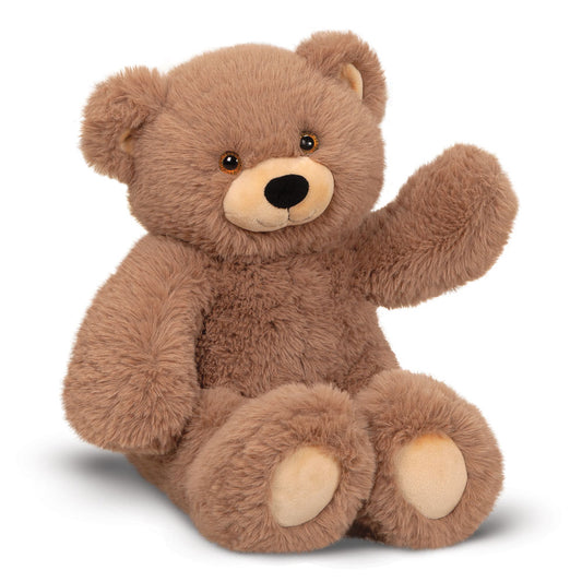 Light brown plush teddy bear with dark eyes, tan snout, and cream paw pads sitting and raising one arm.