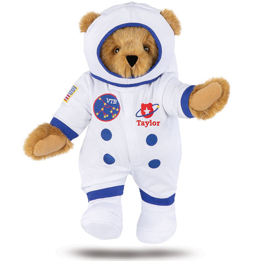 Honey-colored plush bear wearing a white astronaut suit with blue accents and personalized name "Taylor" embroidered on chest.