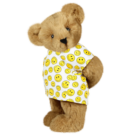 Honey-colored teddy bear wearing a white shirt with yellow smiley faces and brown eyes.